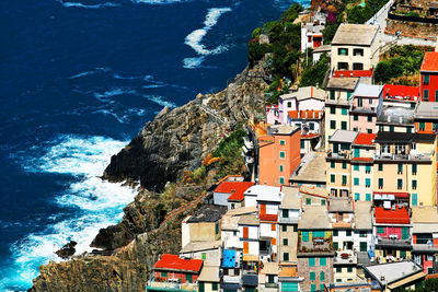 High angle view of riomaggiore village on mountain by sea