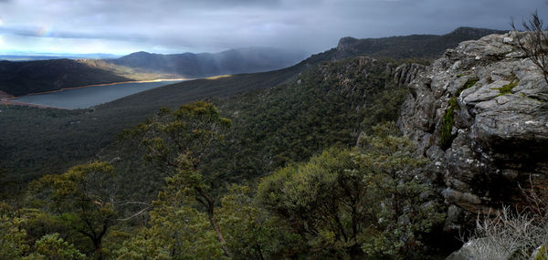Scenic view of rain in valley over lake from high mountain pass