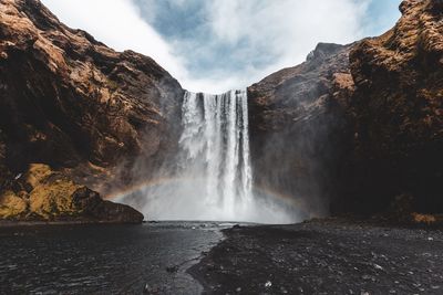 Scenic view of waterfall against sky