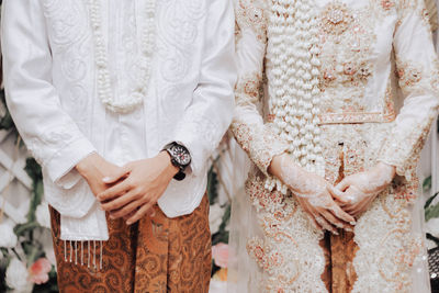 Midsection of couple holding hands
