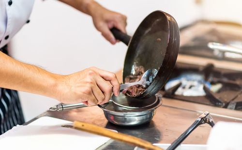 Midsection of man preparing food in kitchen at home