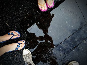 Low section of woman standing in puddle