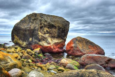 Rock formation on beach against sky