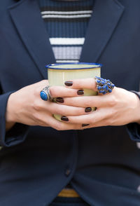 Mid section of woman holding coffee cup