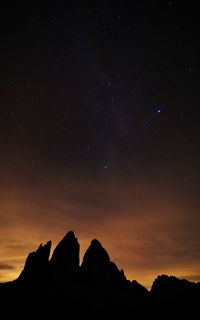 Low angle view of silhouette mountain against sky at night