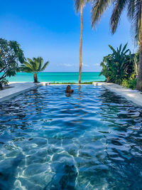 Swimming pool by sea against sky