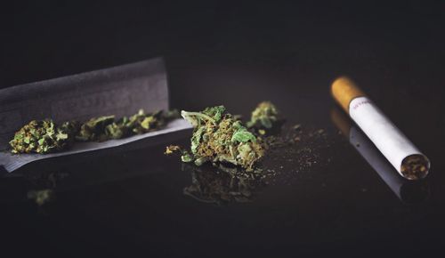 Close-up of cigarette on table against black background