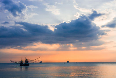 Sailing ships in sea against sky during sunset