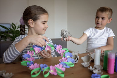 Kids create easter flower wreath in pastel colors using an upcycled egg trail. zero waste lifestyle