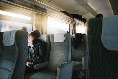 Rear view of man sitting on seat in bus