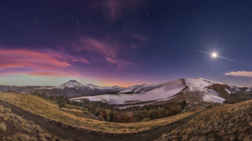 Scenic view of mountains against sky at night