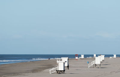 Chairs on beach against sky