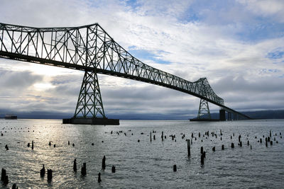 View of bridge over sea against cloudy sky