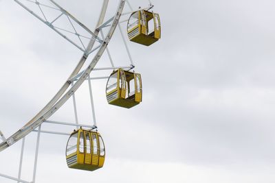 Low angle view of overhead cable cars against sky