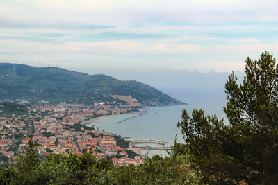 Aerial view of townscape by mountain against sky