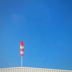 Low angle view of flag against clear blue sky