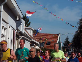 Group of people in traditional building against sky in city