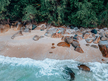 High angle view of a couple on rocks by sea