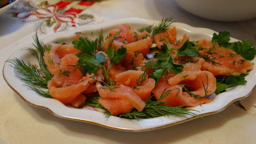 Close-up of salad with salmon in plate on table