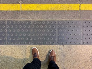 Low section of man standing on road