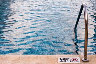 High angle view of no diving sign by swimming pool