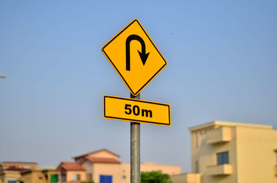 Close-up of road sign against sky 