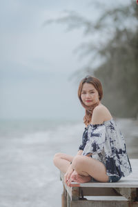 Portrait of woman standing against sky