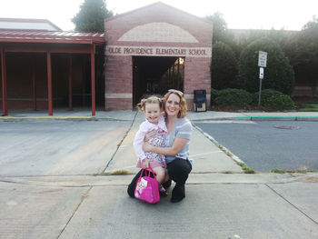 Side view of young woman sitting on street