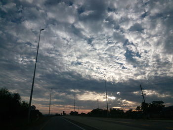 Silhouette street against sky during sunset