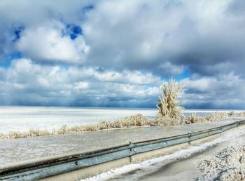 Scenic view of snow covered landscape against cloudy sky