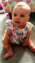 Portrait of cute baby girl sitting at home