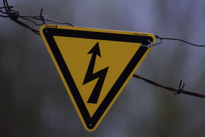 Close-up of sign on barbed wire