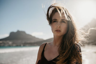 Portrait of beautiful woman against water