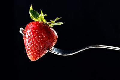 Close-up of strawberry over black background