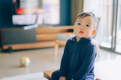 Portrait of cute boy sitting at home