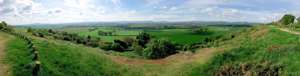 Panoramic view of agricultural field against sky