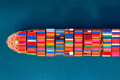 High angle view of multi colored pencils on table against blue wall