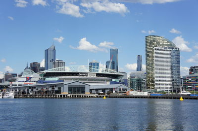 City at waterfront against cloudy sky