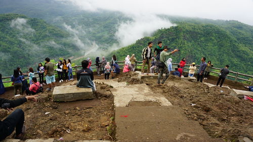 People on mountain against mountains
