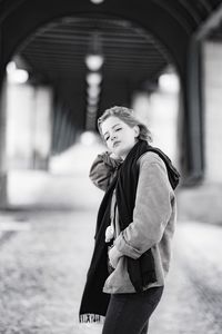 Woman standing under bridge 