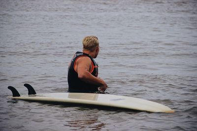 Rear view of man surfing in water