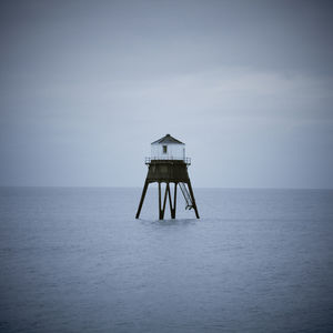 Lifeguard hut in sea against sky