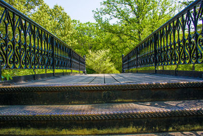 Boardwalk with metallic railing against trees