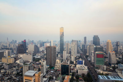 Aerial view of buildings in city against sky