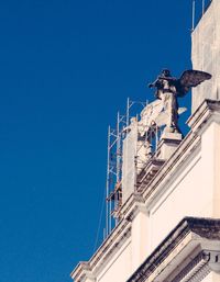 Low angle view of built structure against clear blue sky