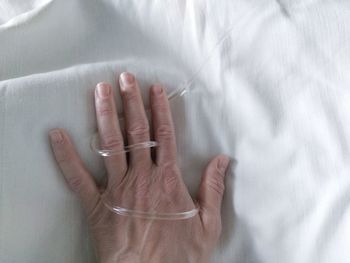 Close-up of woman hand on bed