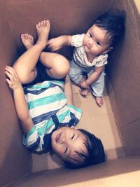 Cute siblings resting in cardboard box