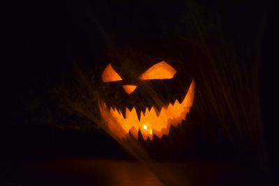 Close-up of illuminated pumpkin against black background