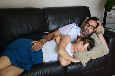 Couple sleeping on sofa at home