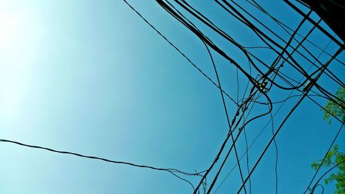 Low angle view of barbed wire against clear blue sky